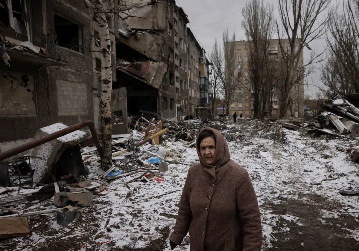Una mujer pasa por bloques de apartamentos que fueron destruidos en un ataque con misiles rusos en Selydove, cerca de Avdiivka, Ucrania