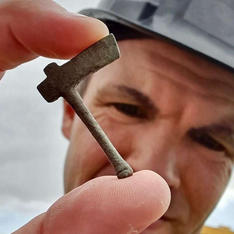 Uno de los arqueólogos sosteniendo uno de los diminutos martillos votivos.