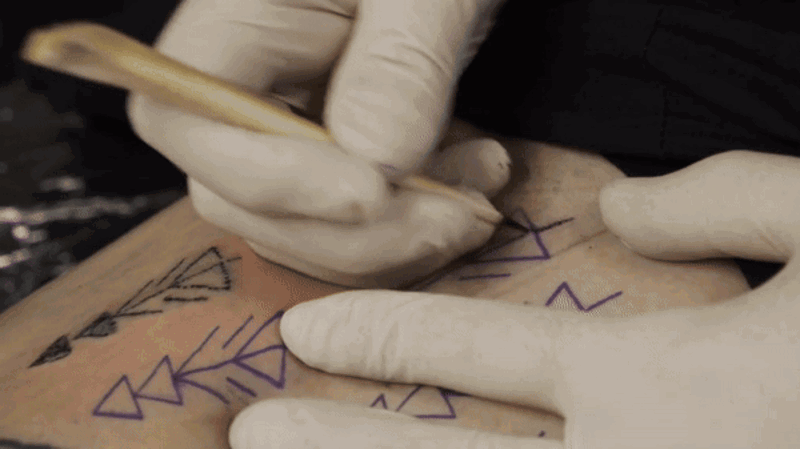 Esta imagen muestra a uno de los autores del estudio, Danny Riday, tatuándose su propia pierna con un punzón hecho con un hueso de venado.