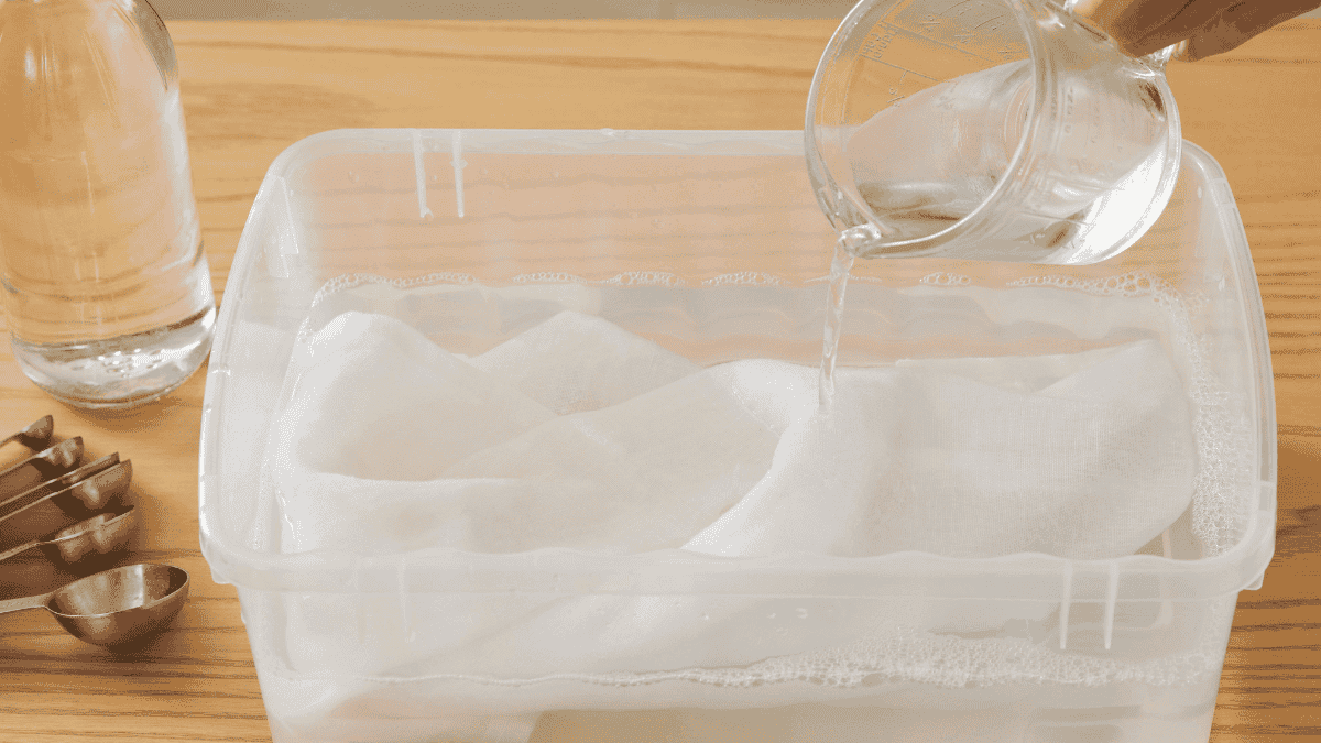 Prenda de ropa sumergida en un recipiente con agua y vinagre